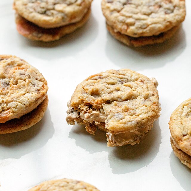 These chewy cookies are full of Butterfingers and stuffed with peanut butter buttercream; it's basically salty-sweet perfection | www.spachethespatula.com #recipe