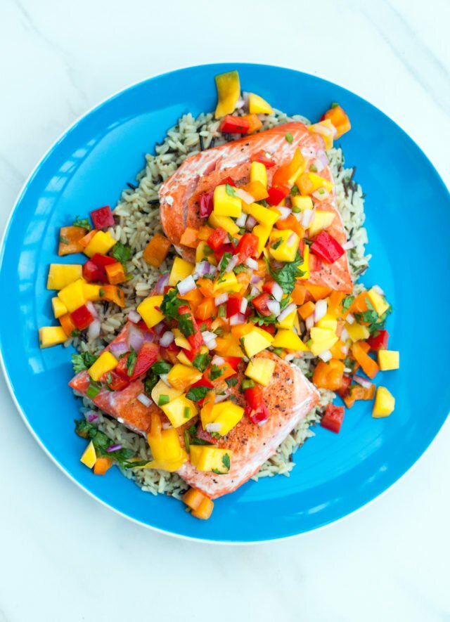 A fresh and vibrant mango salsa tops seared salmon fillets in the perfect Summer dish! | www.spachethespatula.com #recipe